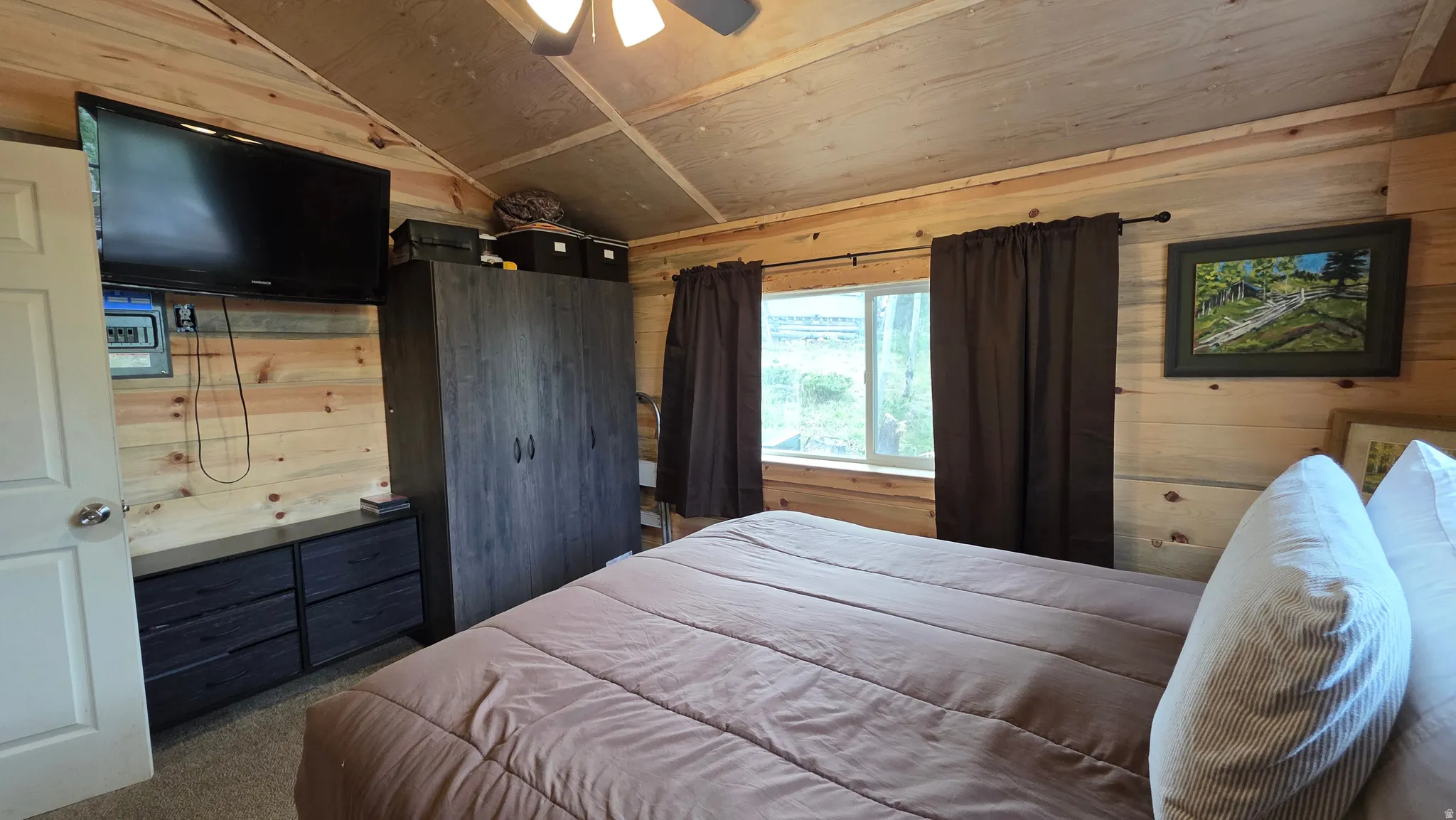 Wood-paneled interior room featuring a light wood ceiling with exposed beams