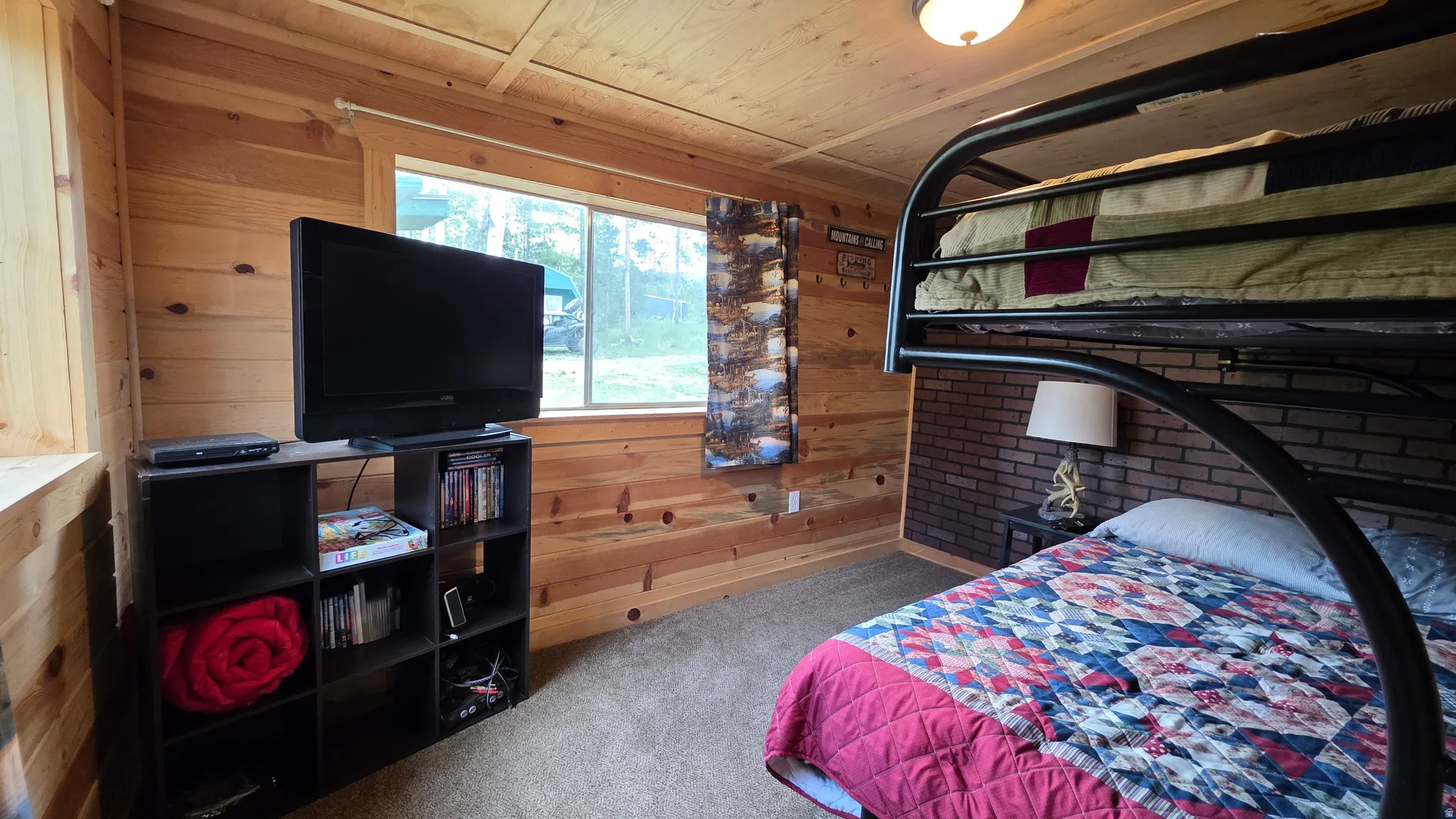 Room featuring natural wood plank walls, a large window, and a built-in bunk bed structure