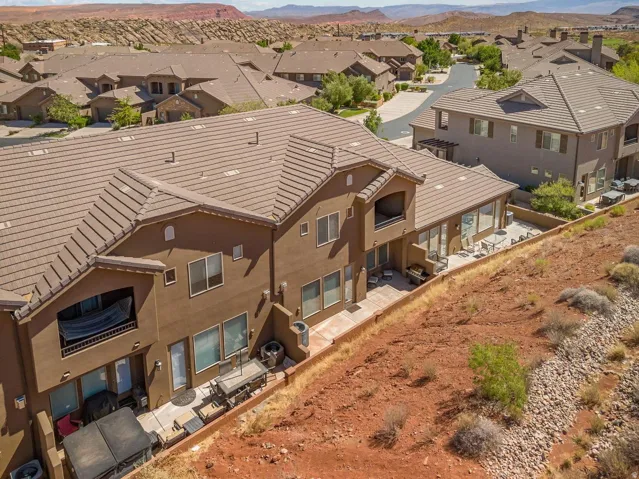 Two-story stucco residence featuring multiple balconies and extensive rear patio space