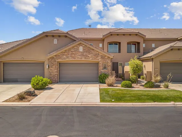 Stucco exterior with stone accents and multiple garage doors