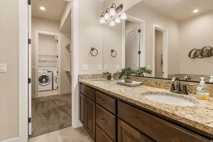 Dual vanity with granite countertops, dark wood-finish cabinetry, and oil-rubbed bronze fixtures