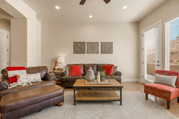Spacious living area featuring light-toned walls, wood-finish flooring, recessed lighting, and a ceiling fan