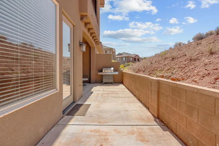Outdoor patio with concrete slab flooring and a block privacy wall