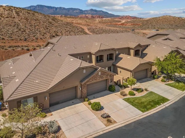 Exterior featuring a multi-tone tile roof, stucco siding, and stone accents on the garage facade