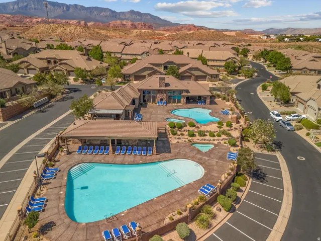 Community amenity center featuring a large swimming pool, an additional smaller pool, and a shaded pergola area with seating