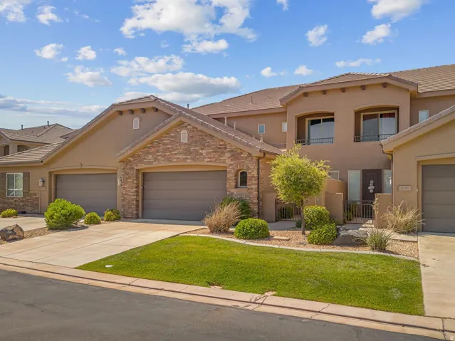 Multi-level stucco exterior with stone accents and arched window details