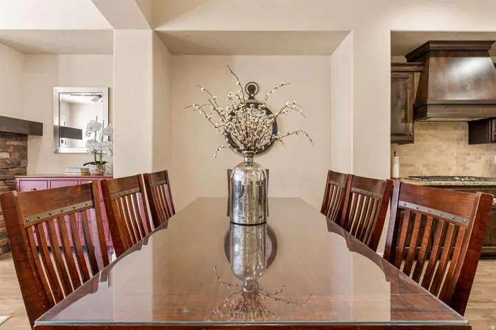Dining area with a large wood-finish table and glass top