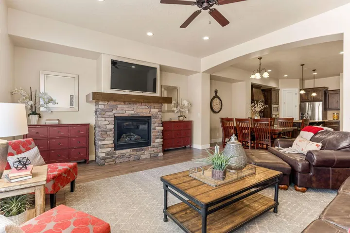 Living area featuring a stone-clad fireplace with wood mantel, recessed lighting, and a ceiling fan