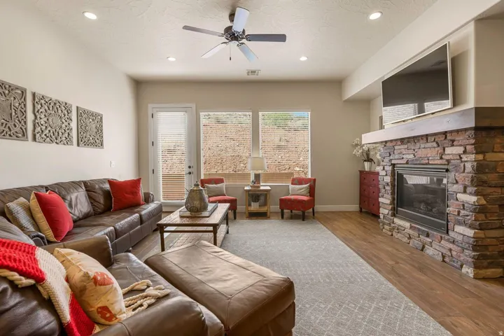 Living room featuring a stacked stone fireplace with a substantial wood mantelpiece