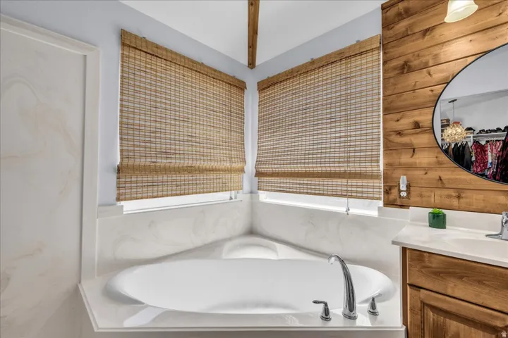 Soaking tub with deck-mounted chrome fixtures set in a light-toned countertop