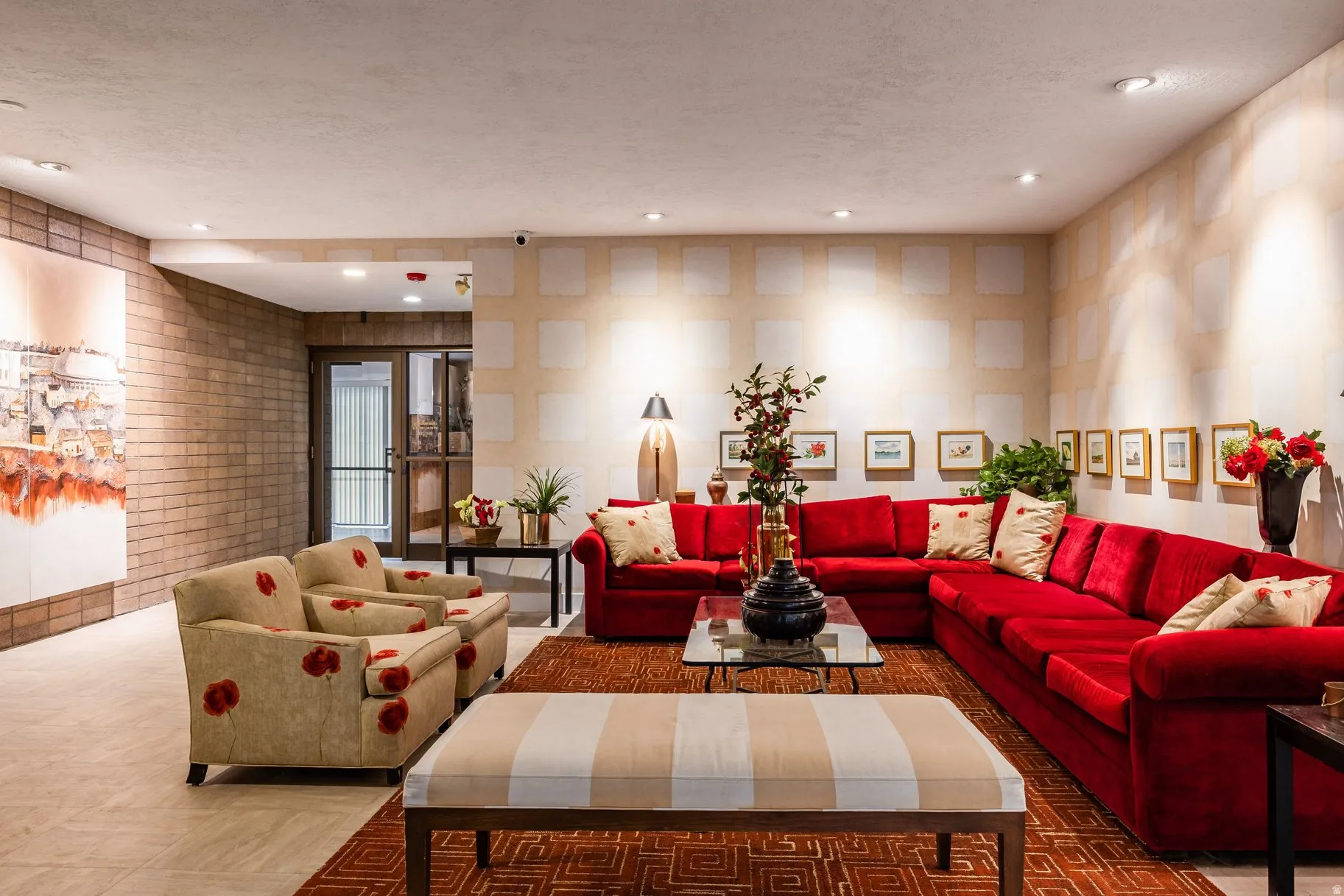 Spacious common area featuring a light-colored brick accent wall, recessed lighting, and tile flooring