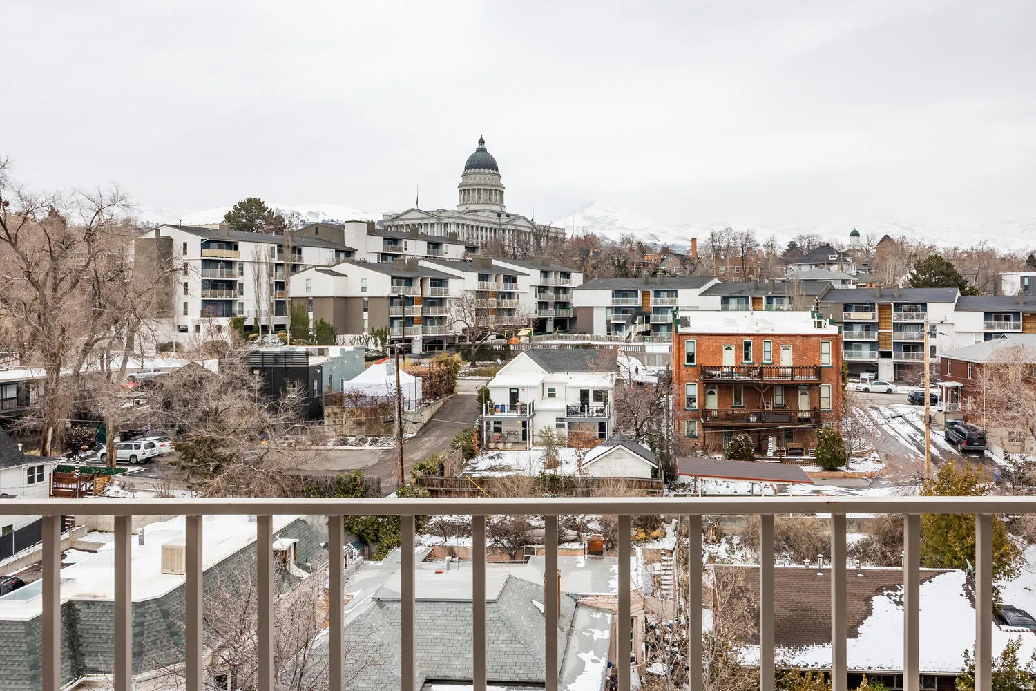 Rooftop perspective showcasing surrounding architecture, distant mountain ranges, and a prominent domed building