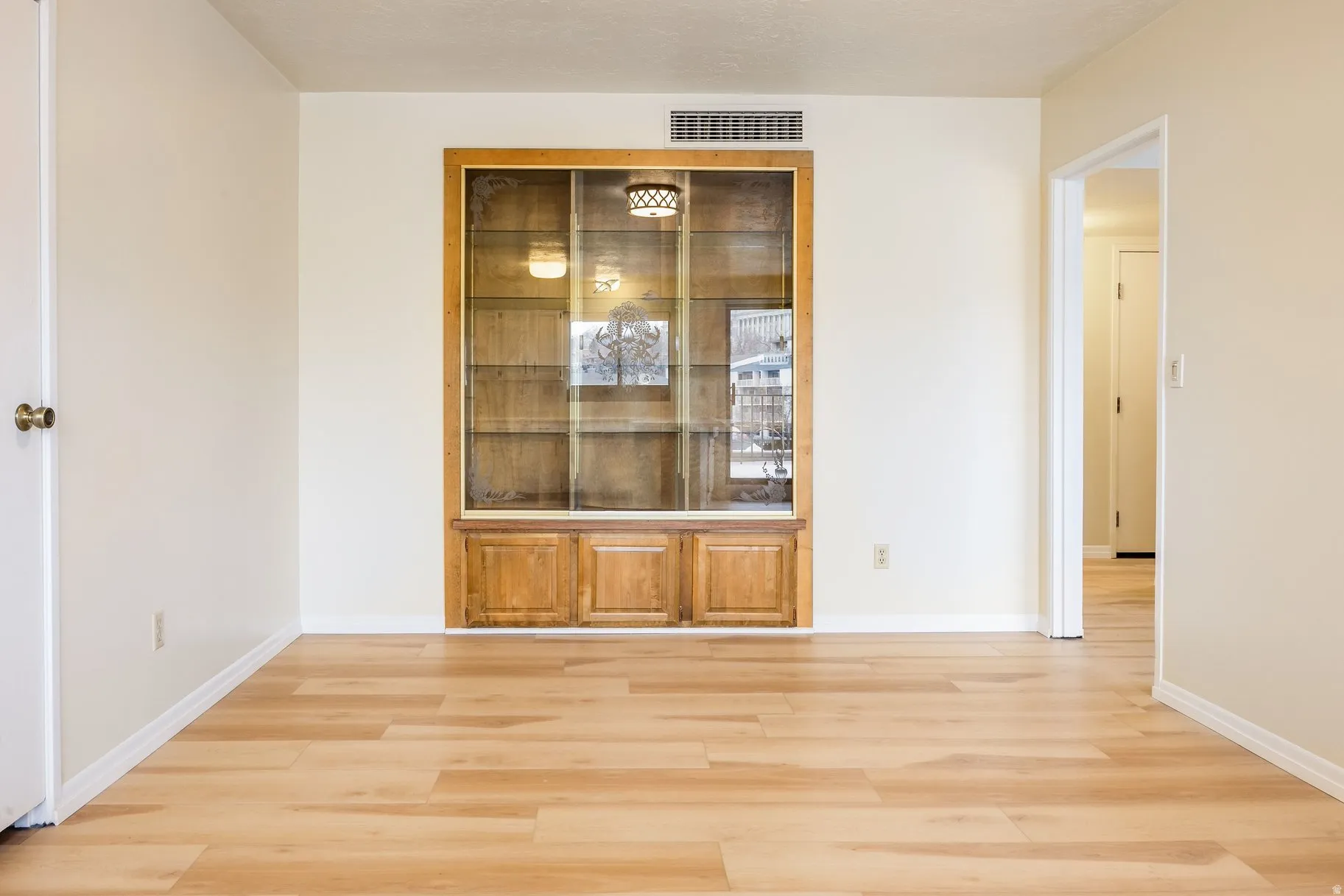 Built-in wood display cabinet with glass doors and integrated lighting
