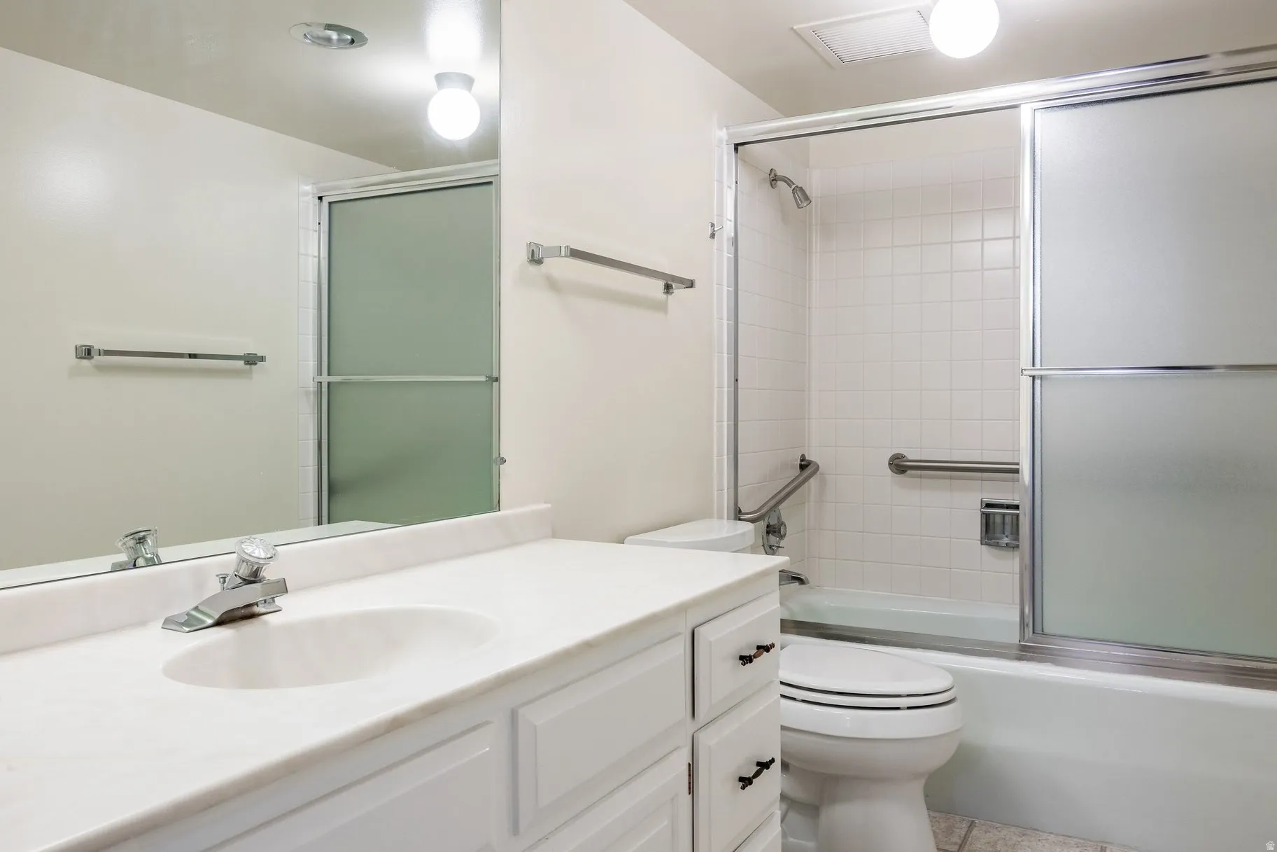 Bathroom featuring a white vanity with an integrated sink, polished chrome faucet, and a large wall-mounted mirror