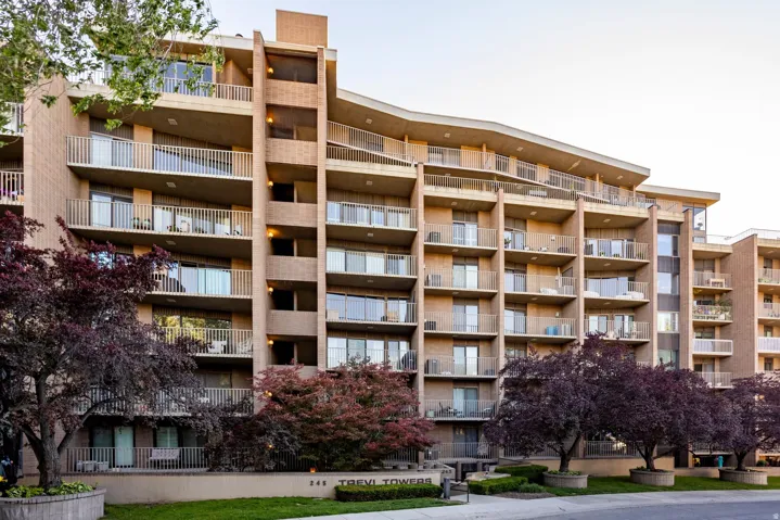 Multi-story residential building featuring a brick facade with individual balconies