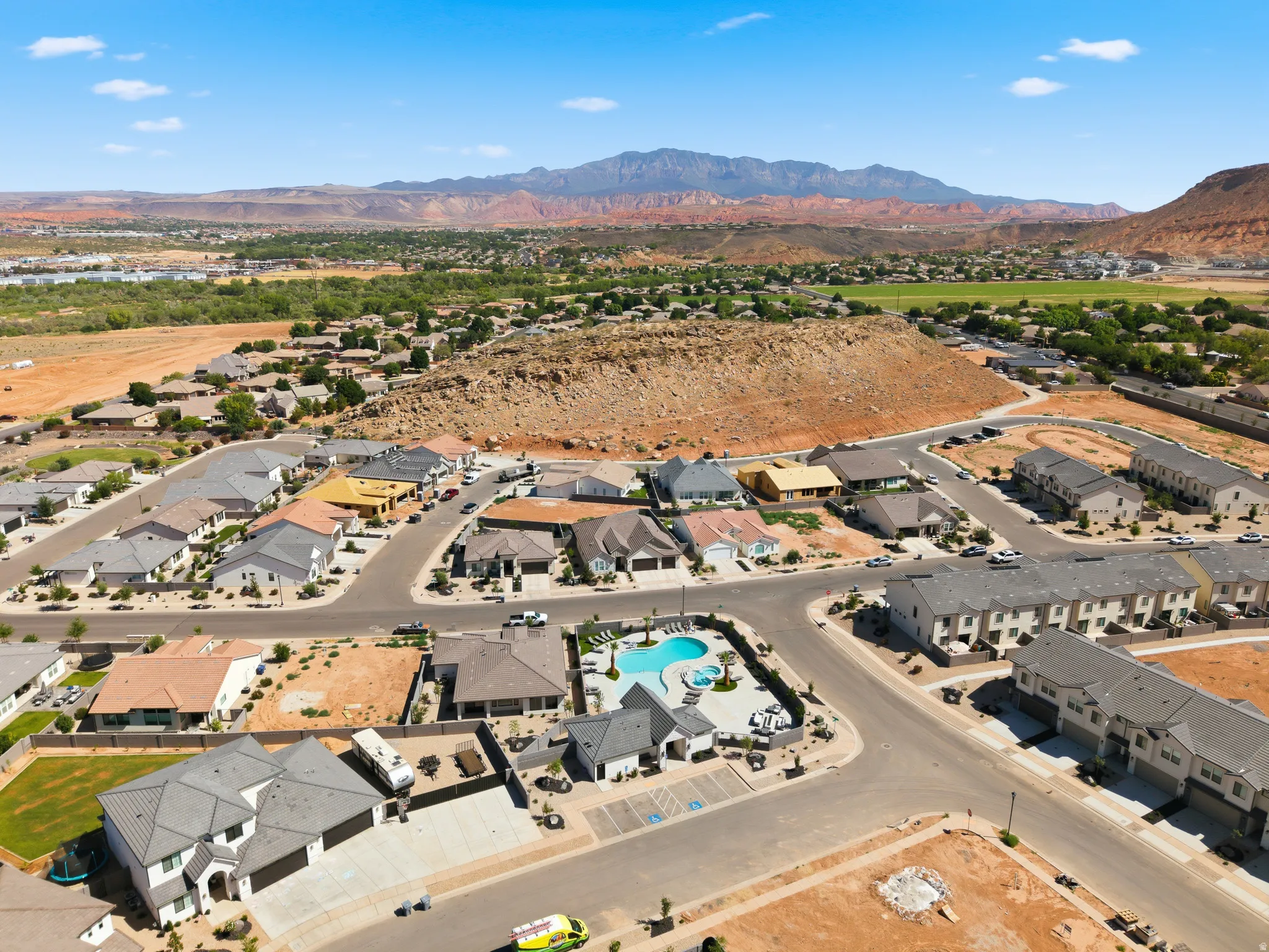 Aerial community overview featuring a central swimming pool and surrounding residential properties