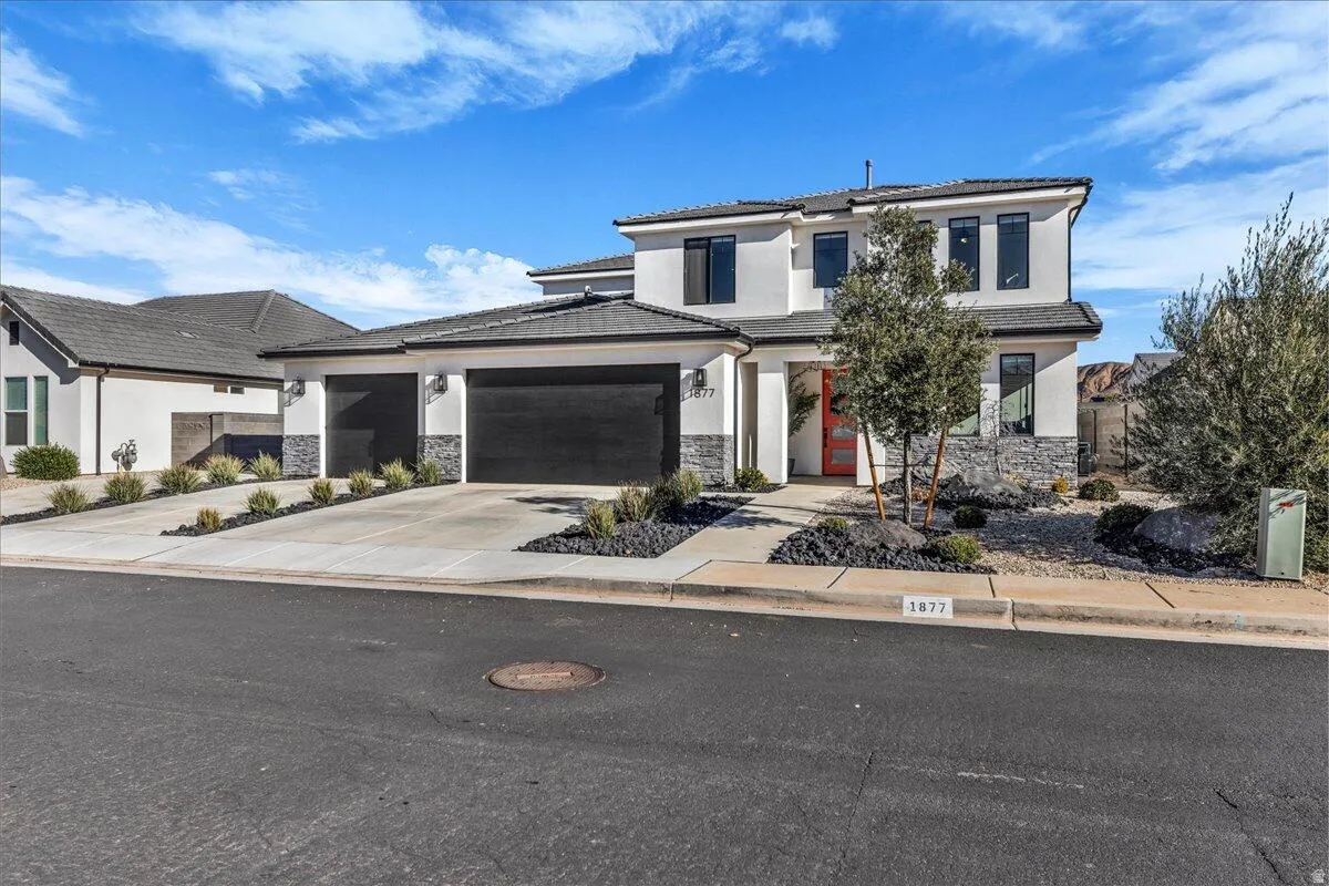 Contemporary two-story exterior featuring a stucco facade and stone accents