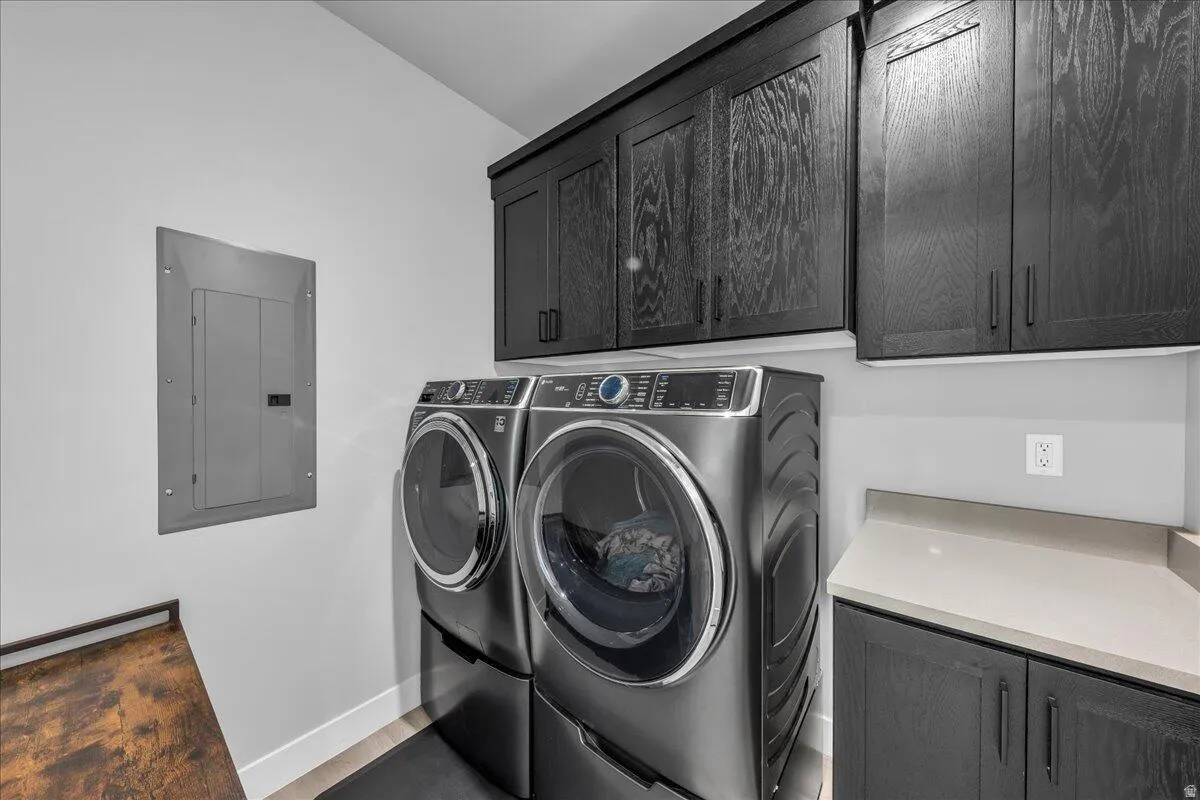 Laundry area featuring dark wood-finish cabinetry, light countertop, and a wood-finish shelf