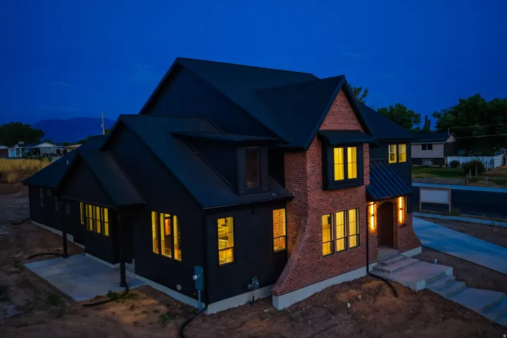 Modern residence featuring a dark siding facade and red brick accents