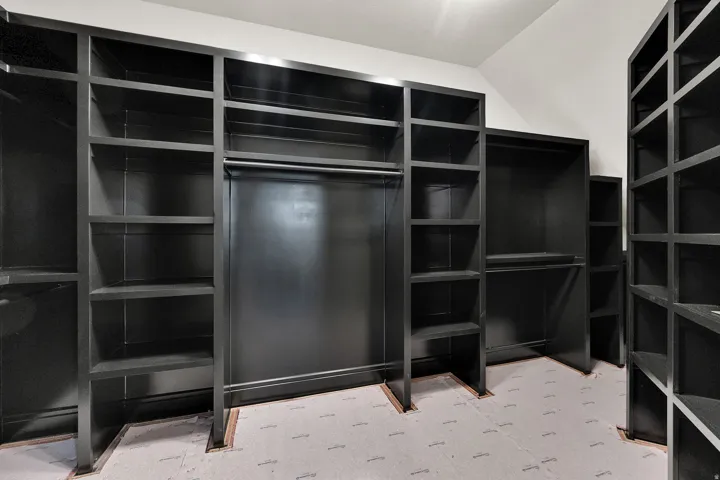 Custom closet system featuring dark-finish shelving and integrated hanging rods