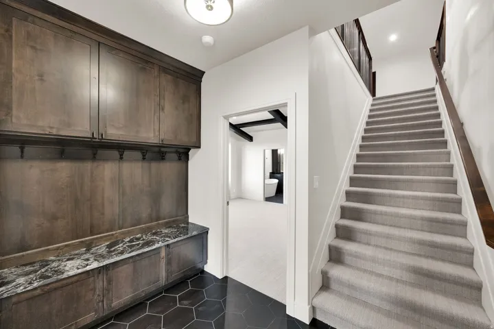 Built-in wood cabinetry with storage hooks and a stone countertop