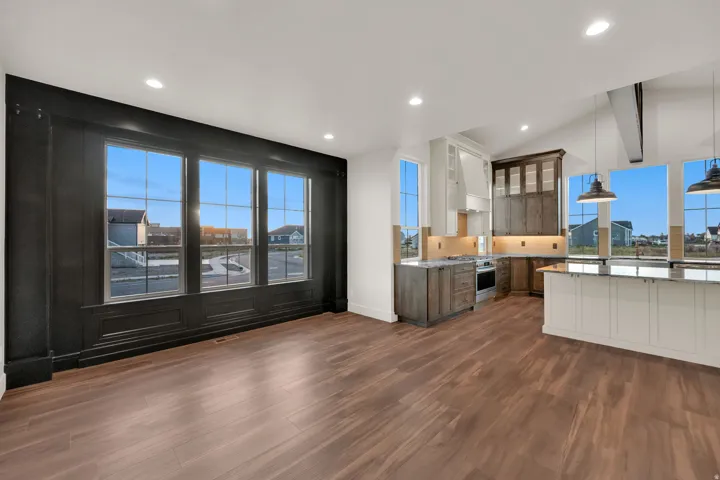 Open-concept living space featuring wood-finish flooring, recessed lighting, and a kitchen with an island