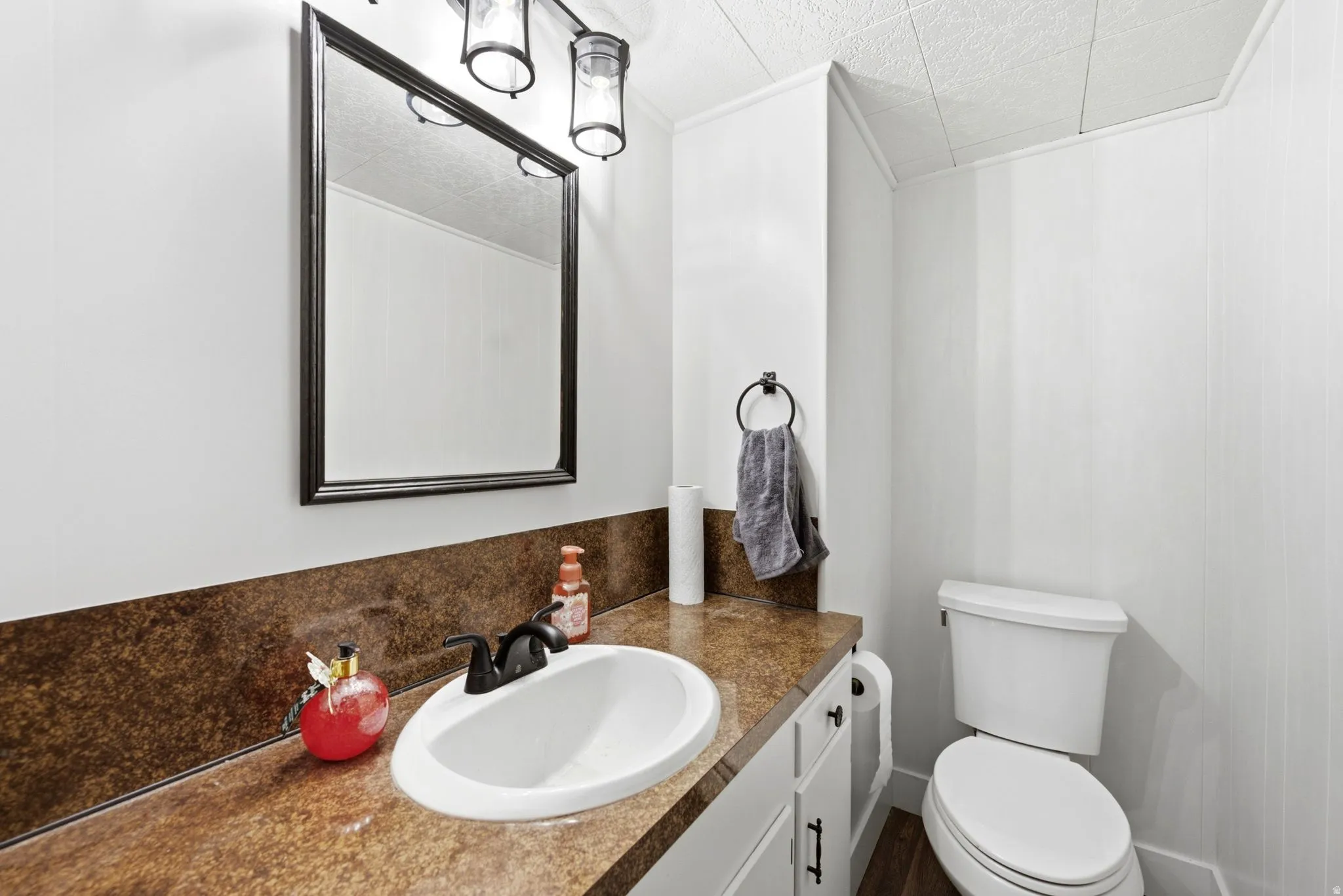 Bathroom vanity featuring a dark countertop with an integrated sink and matte black faucet