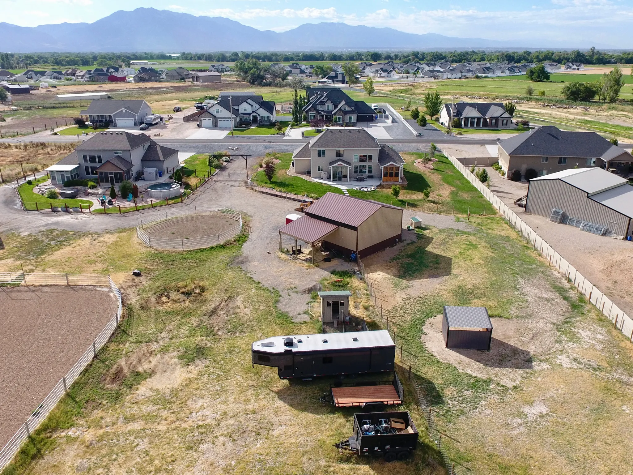 Expansive property featuring a gravel driveway, multiple outbuildings, and fenced areas