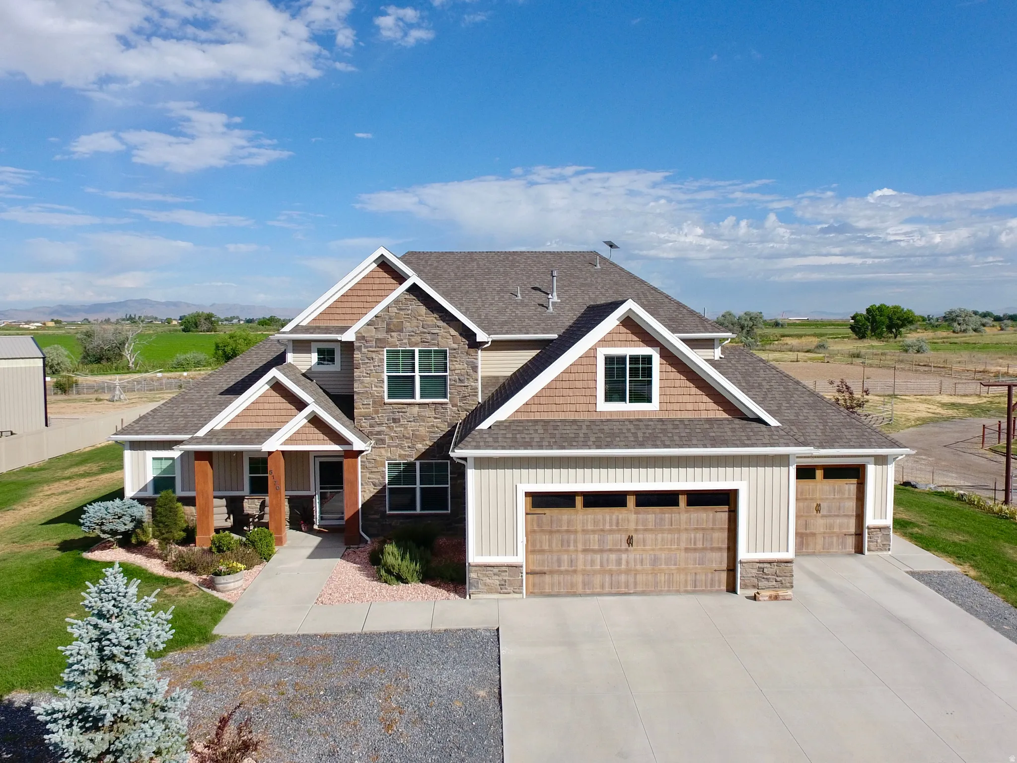 Modern craftsman-style residence featuring a stone and siding exterior