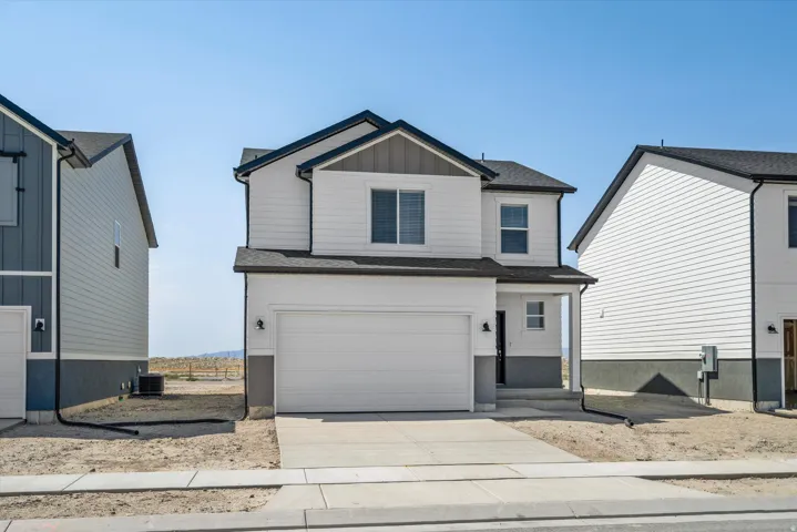 Contemporary two-story exterior with white siding, dark gray trim, and a two-car garage