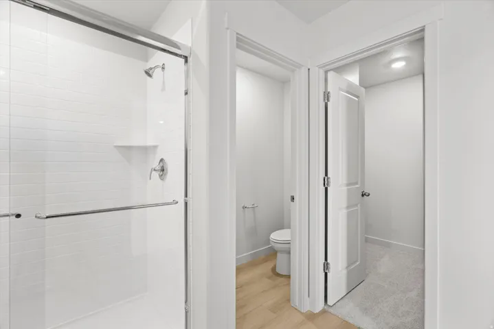 Walk-in shower with clear glass enclosure and subway tile surround
