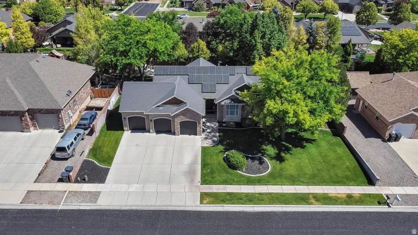 Contemporary residence featuring a three-car garage, concrete driveway, and established front landscaping