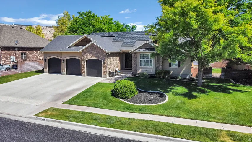 Stone and stucco exterior featuring a three-car garage with arched doors