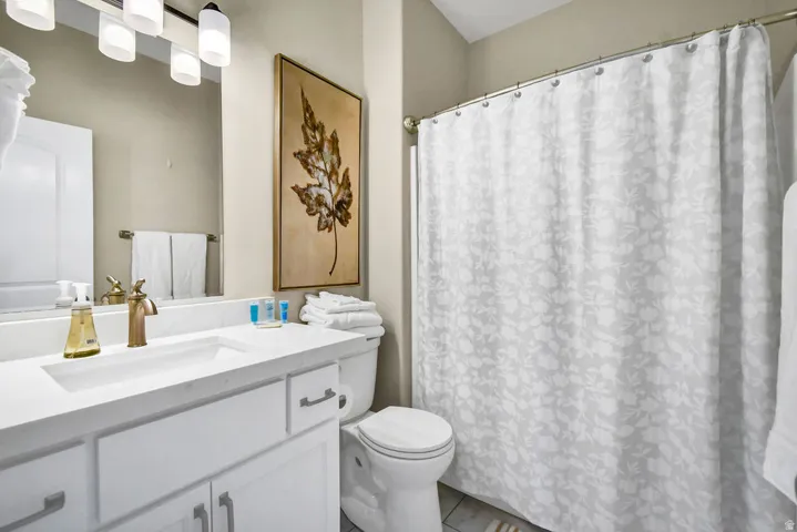 Modern vanity with a rectangular undermount sink, brass-finish faucet, and white countertop