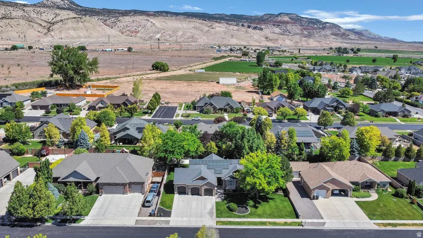 Expansive aerial view showcasing a neighborhood of single-story homes with manicured lawns and mature trees
