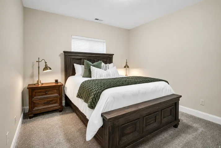 Bedroom featuring neutral wall paint, carpet flooring, a window with blinds, and white trim
