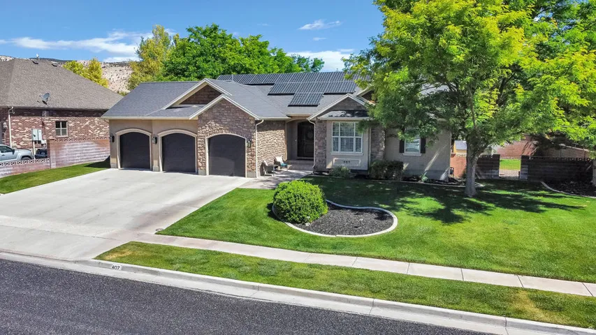 Stone and stucco exterior with an attached three-car garage and solar panels