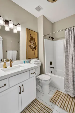 Bathroom featuring a white vanity with integrated sink, gold-finish faucet, and coordinating hardware