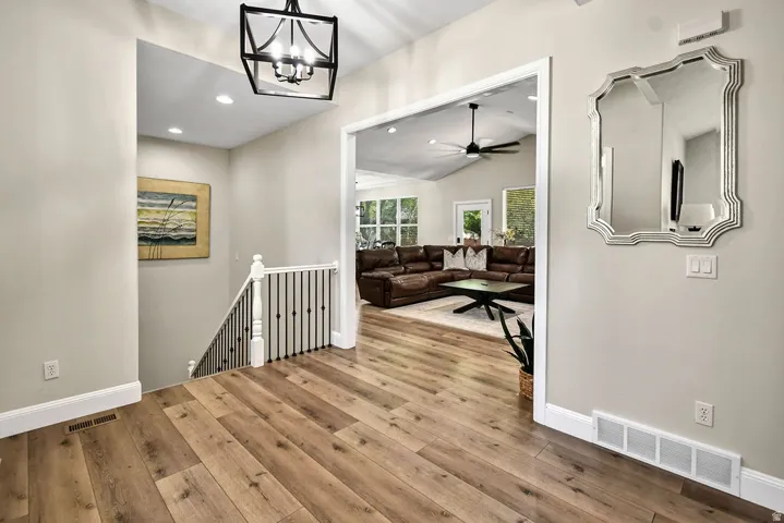 Entryway featuring wood-finish flooring, a contemporary chandelier, recessed lighting, and white baseboards