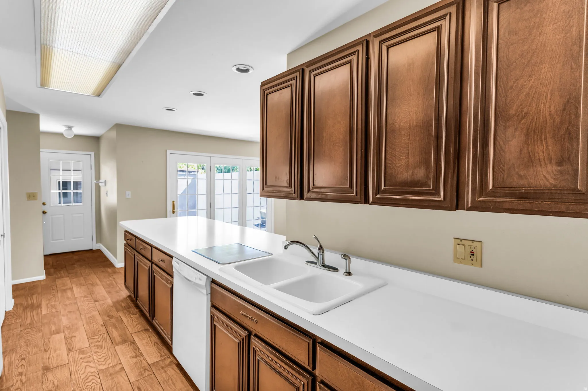Kitchen featuring extensive counter space, wood-finish flooring, and built-in cabinetry
