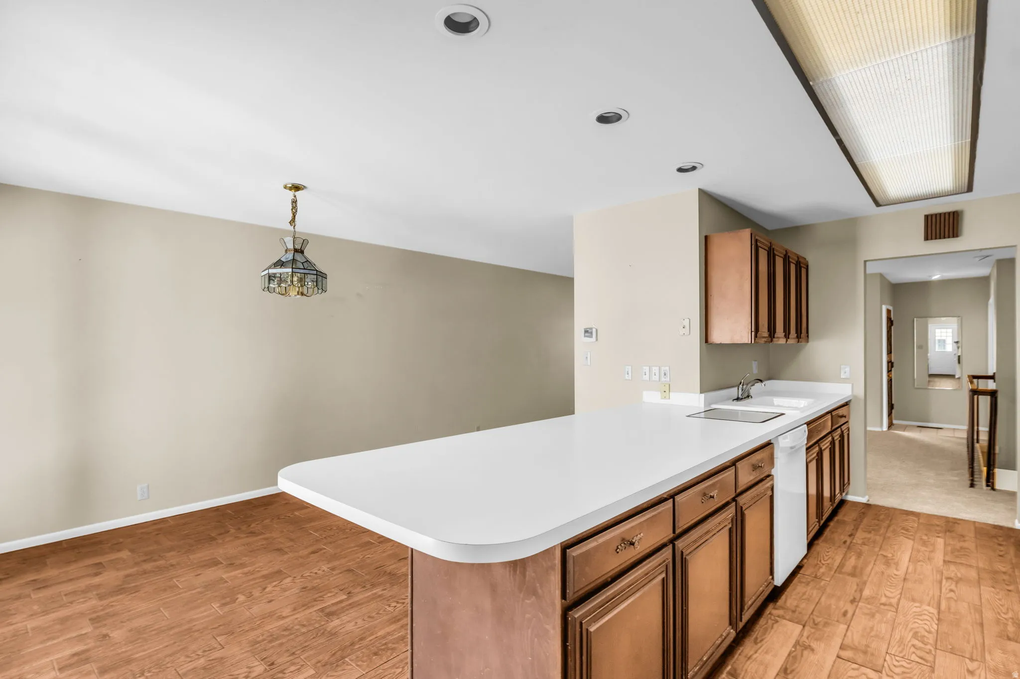 Kitchen island featuring a white countertop and wood cabinetry