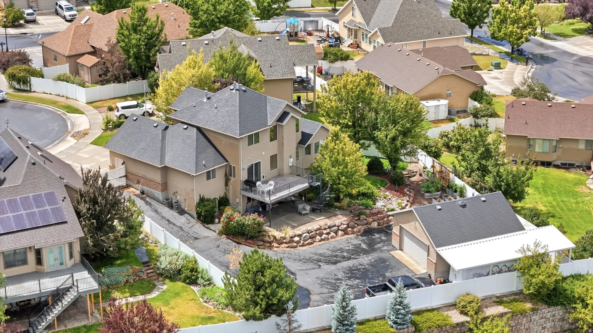 Two-story residence with a tan stucco exterior and dark shingle roof