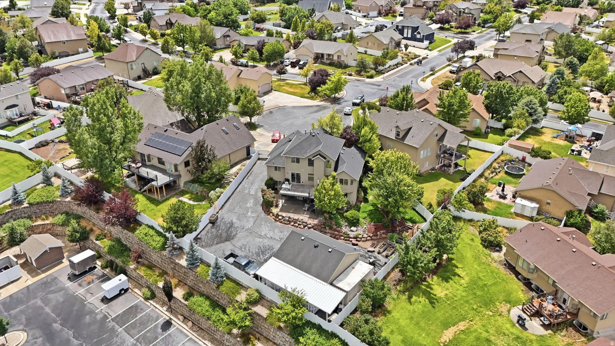 Expansive residential property featuring multiple structures, a paved driveway, and mature landscaping