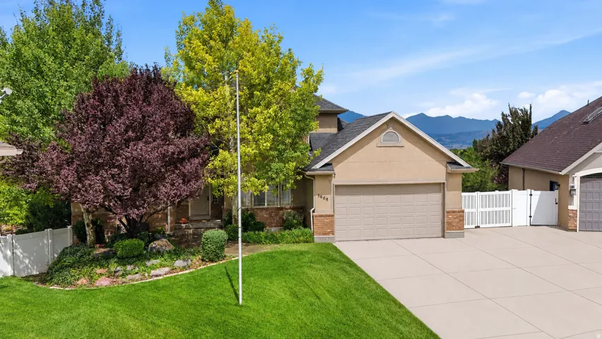 Tan stucco exterior with brick accents and a two-car garage