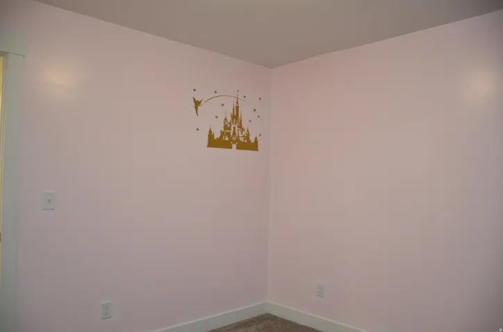 Pink-painted walls with white trim and a textured ceiling