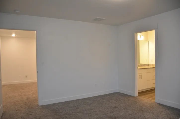 Neutral-toned carpet flooring with white baseboards and walls