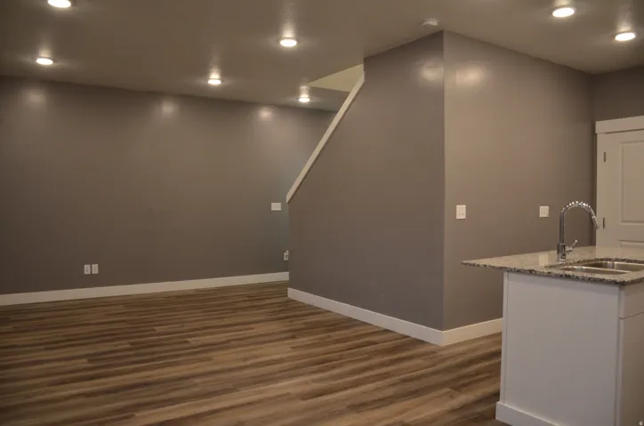 Open-concept living space featuring wood-finish flooring, recessed lighting, and a neutral wall palette