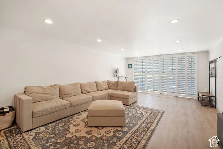 Spacious living room with beautiful LVP flooring ~ large, east facing windows that let in tons of natural light and plantation shutters.