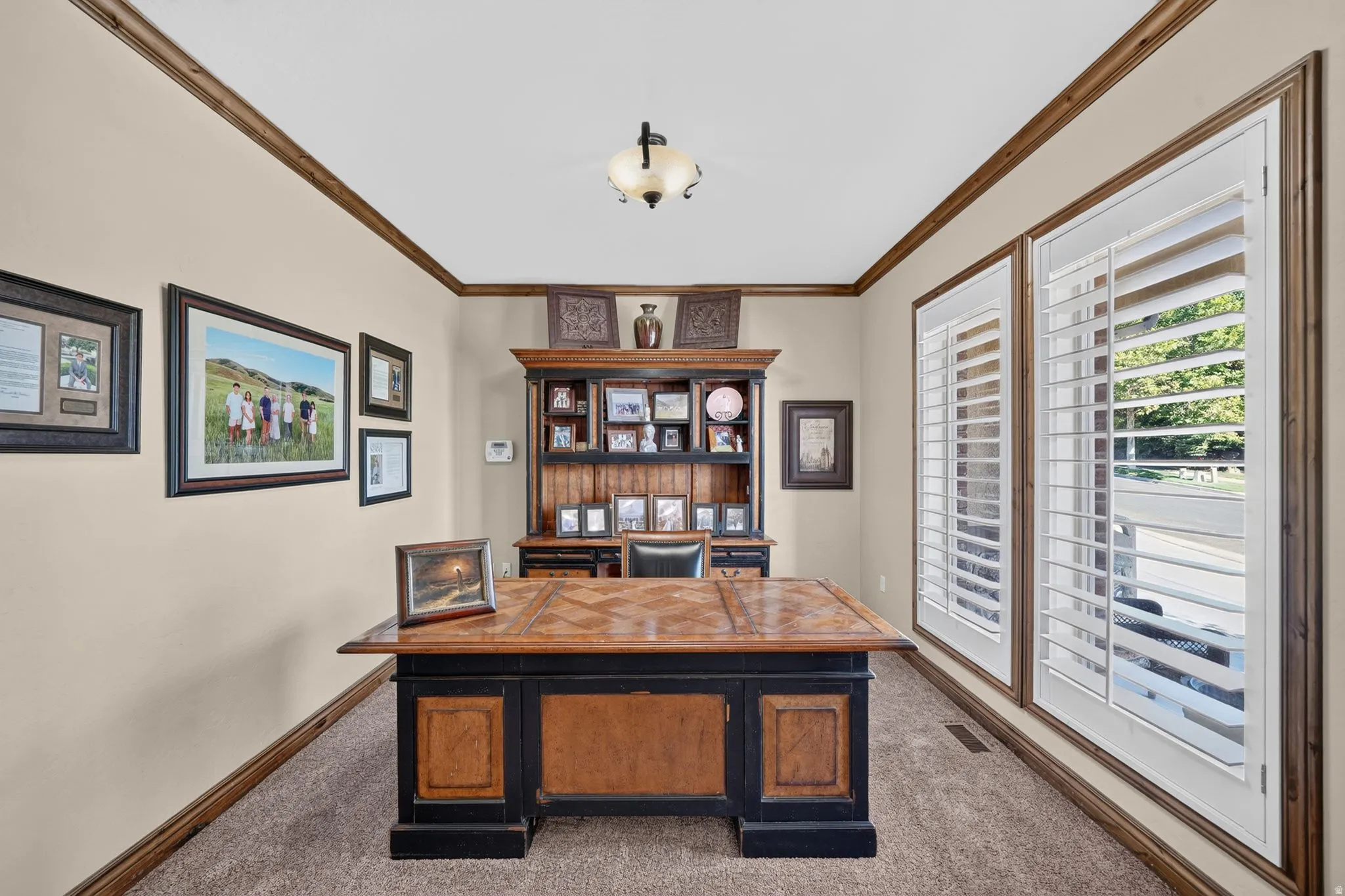 Main level office with large windows and views of the front yard