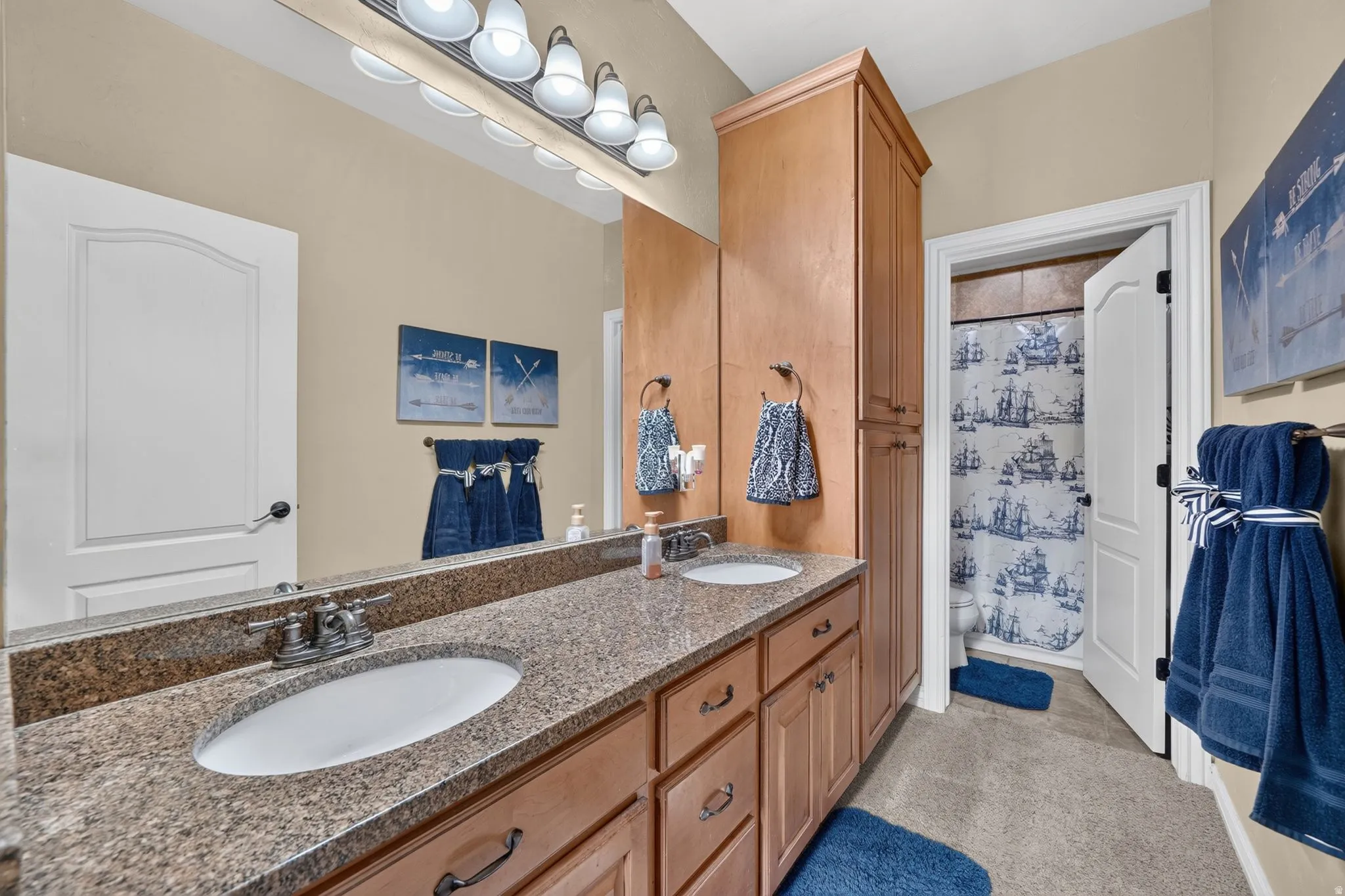 Downstairs bathroom with double vanity sink, walk in shower, and lots of storage space